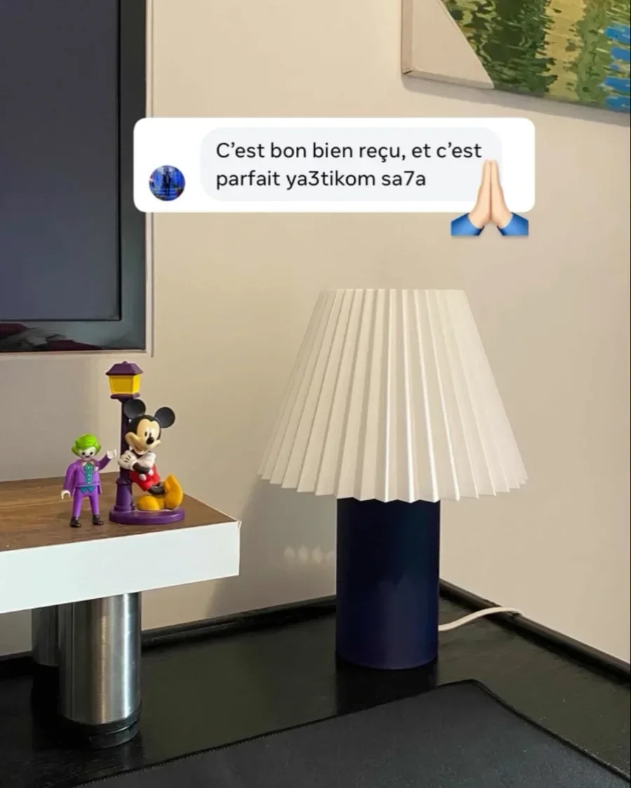 Une Akari bleu nuit sur un bureau, à côté de figurines