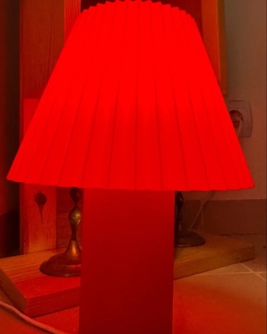 Une Akari rouge allumée dans une niche en bois